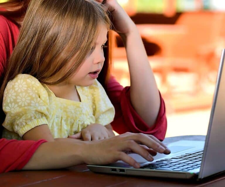 A person sitting at a table using a laptop computer