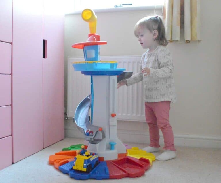 A little girl standing in front of a refrigerator