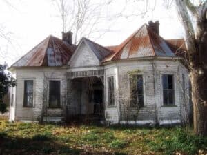 An old brick house with trees in the background