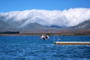 A small boat in a body of water with a mountain in the background