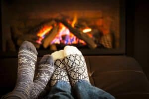 A close up of a person sleeping on a couch next to a fireplace