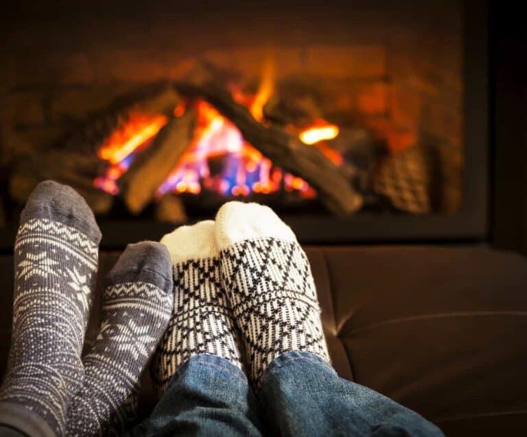 A close up of a person sleeping on a couch next to a fireplace