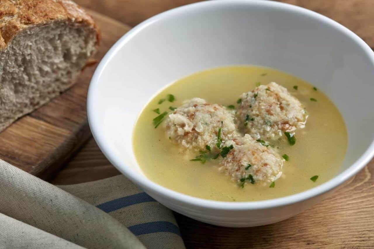 A bowl of soup, with Bread and Chicken