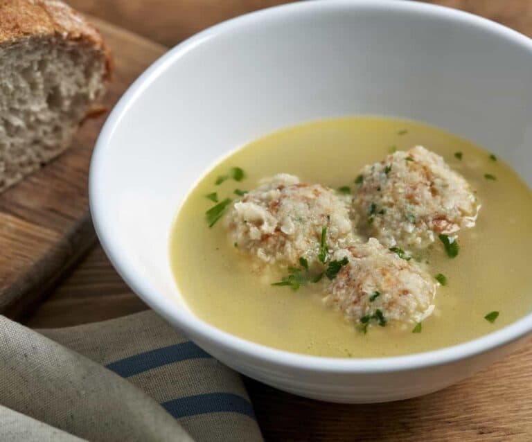 A bowl of soup, with Bread and Chicken