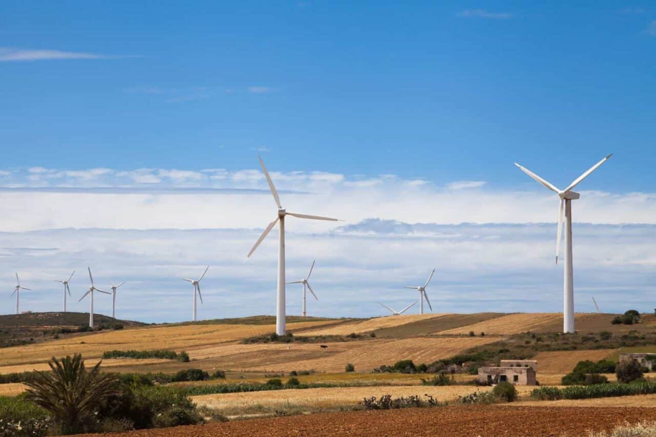 A windmill on top of a grass covered field