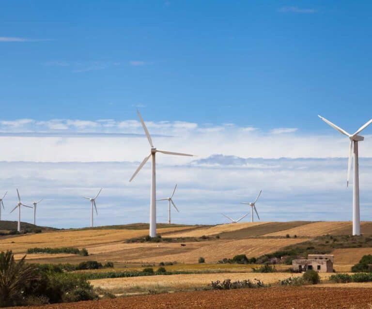 A windmill on top of a grass covered field