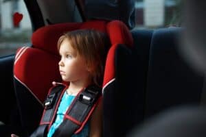 A little boy that is sitting on the seat of a car