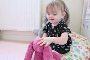 A little girl holding a teddy bear