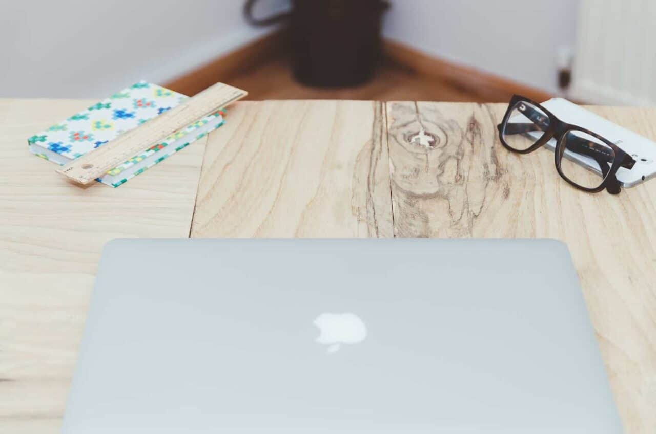 A laptop computer sitting on top of a wooden table