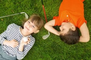 A little boy that is lying down in the grass