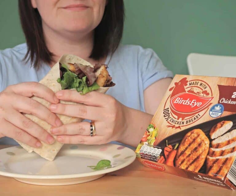 A woman sitting at a table eating a sandwich