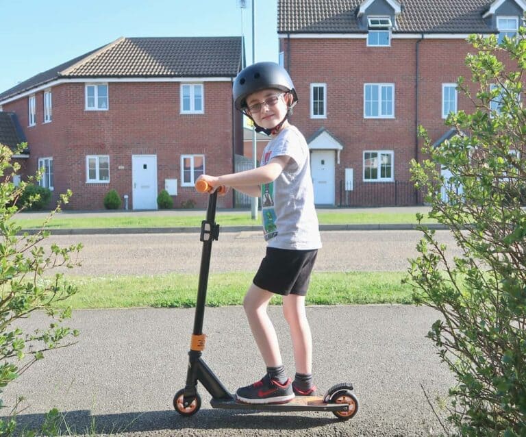 A young boy riding a skateboard up the side of a building