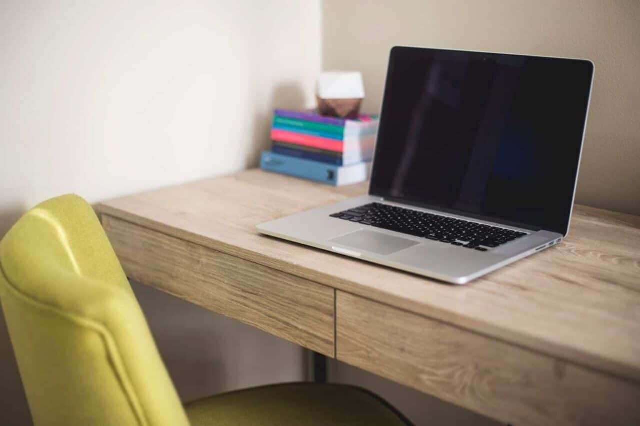 A laptop computer sitting on top of a wooden table