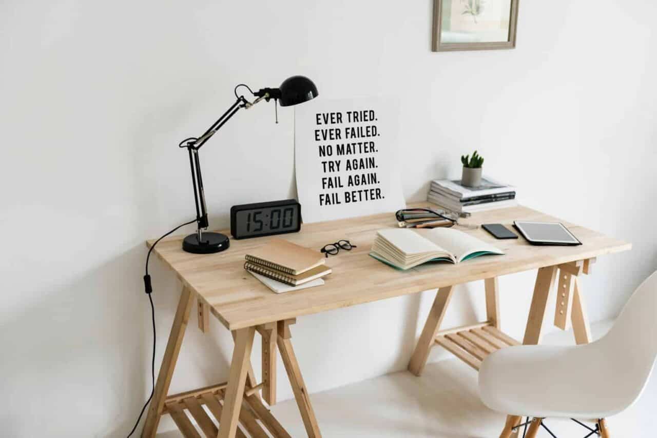 A desk with a laptop computer sitting on top of a wooden chair