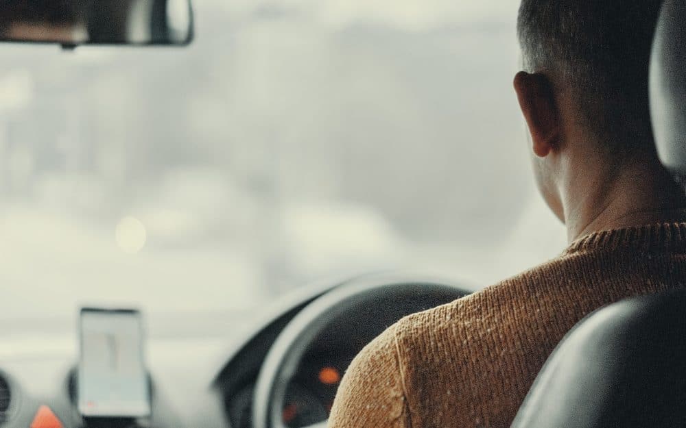 A close up of a man driving a car