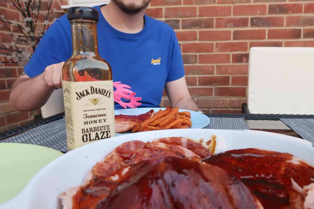 A person sitting at a table with a plate of food, with Barbecue and Gammon