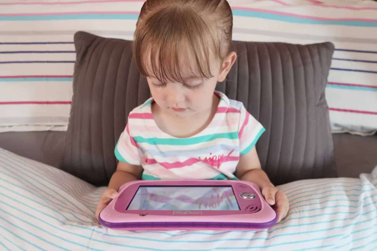 A small child sitting on a bed