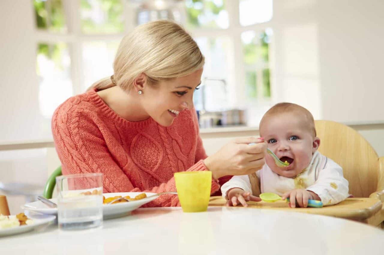 A little girl sitting at a table eating food