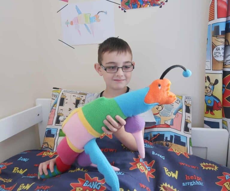 A little boy sitting in a bedroom