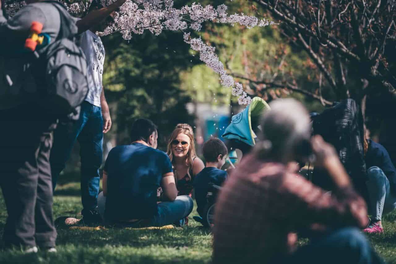 A group of people that are standing in the grass