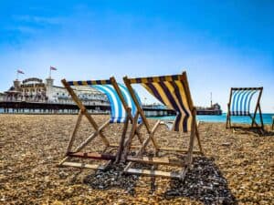 A row of wooden benches sitting on top of a beach