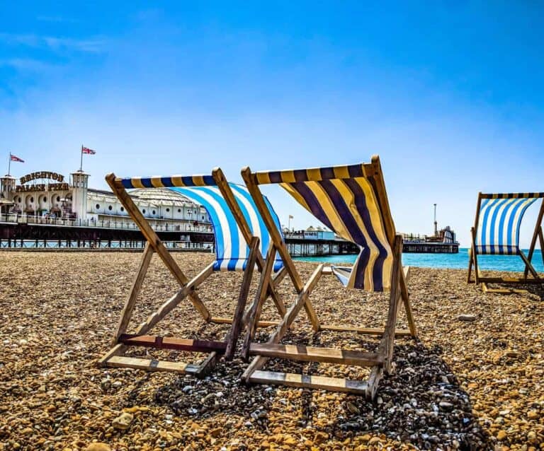 A row of wooden benches sitting on top of a beach