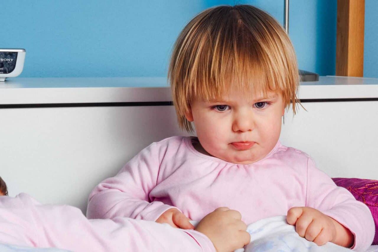 A baby sitting on a bed