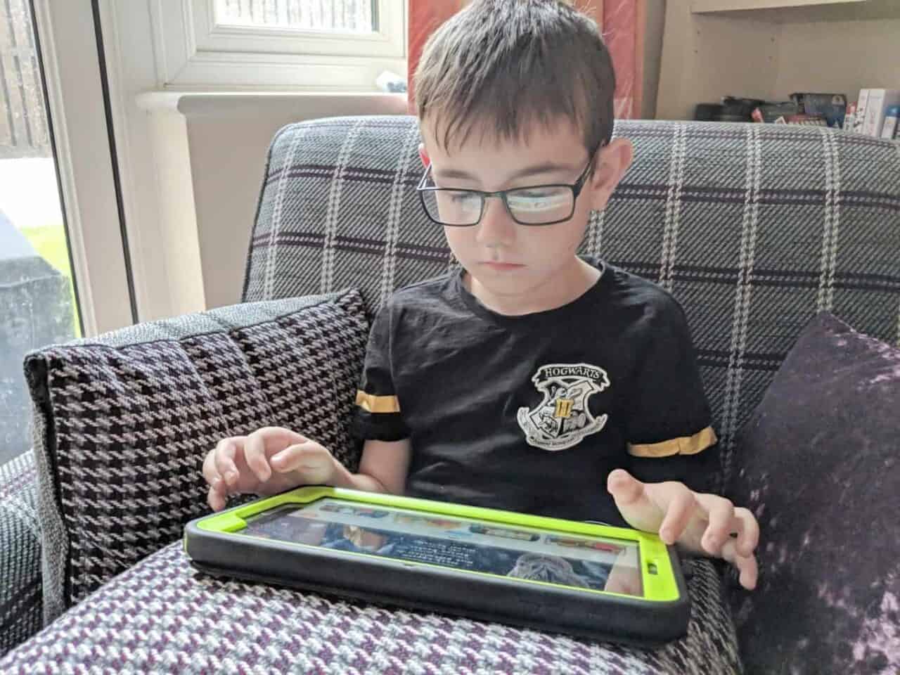 A young boy sitting at a table using a laptop