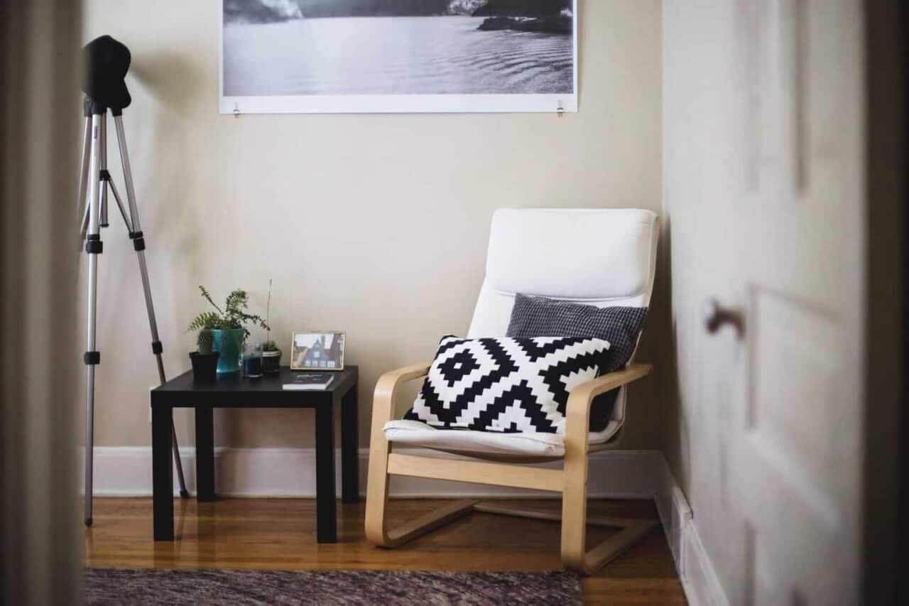 A bedroom with a bed and a chair in a room