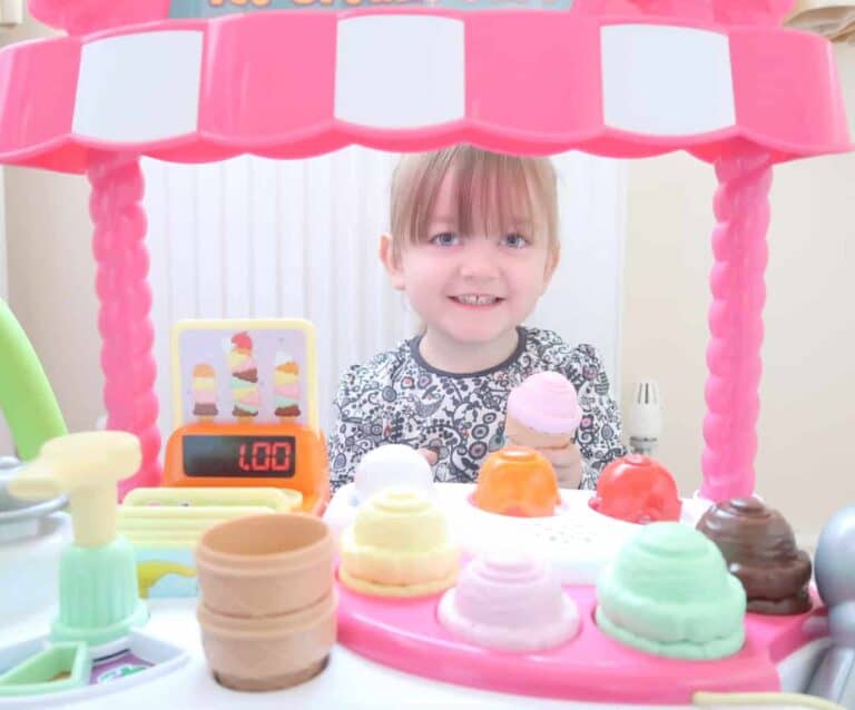 A little girl sitting at a table with a birthday cake