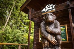 A statue of a bear sitting on top of a wooden pole