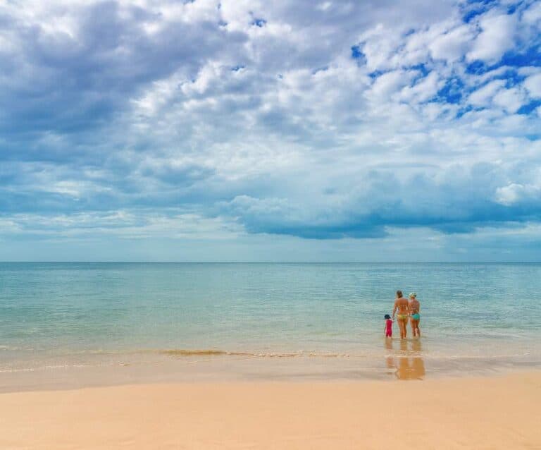 A person sitting on top of a sandy beach