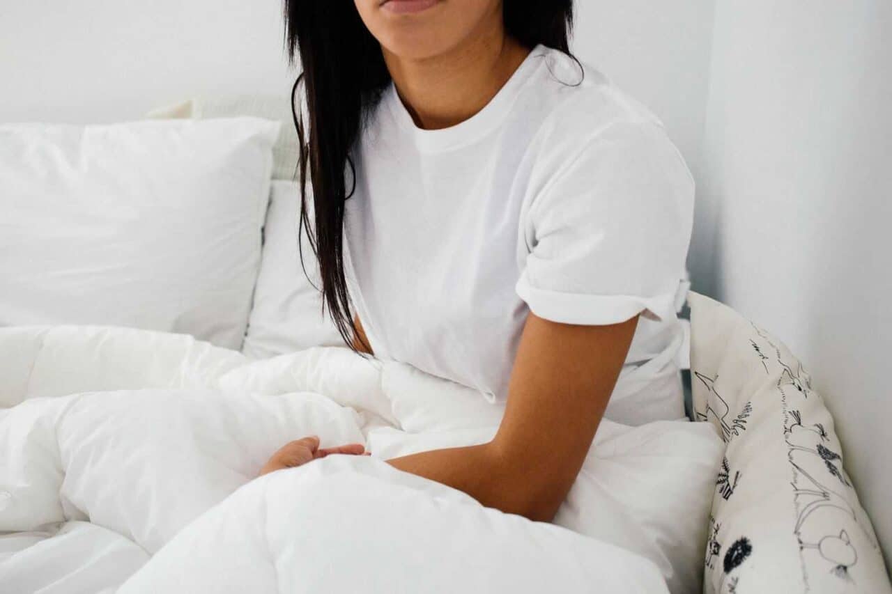 A person sitting on a bed posing for the camera