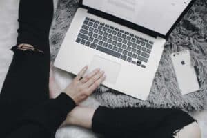 A person sitting next to a laptop