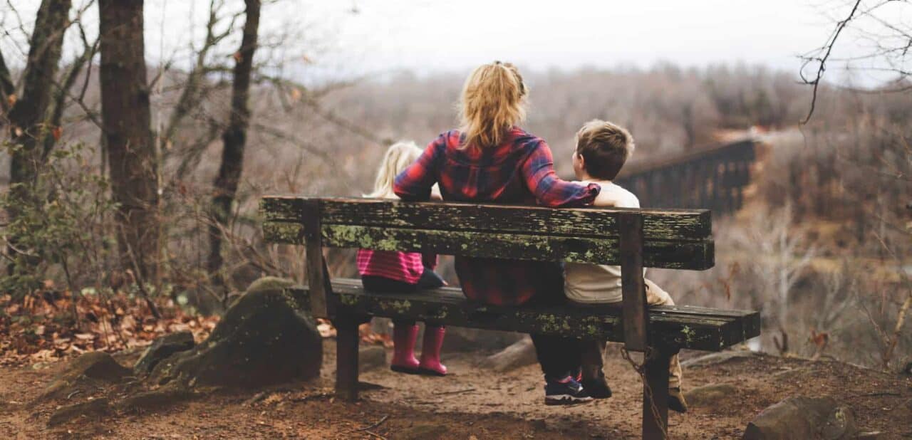 A boy sitting on a bench in a park