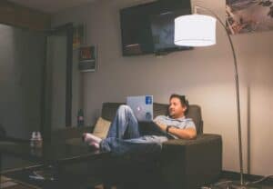 A man sitting on a couch with a laptop