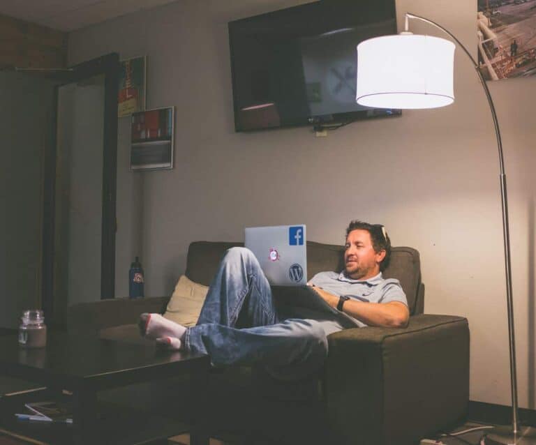 A man sitting on a couch with a laptop