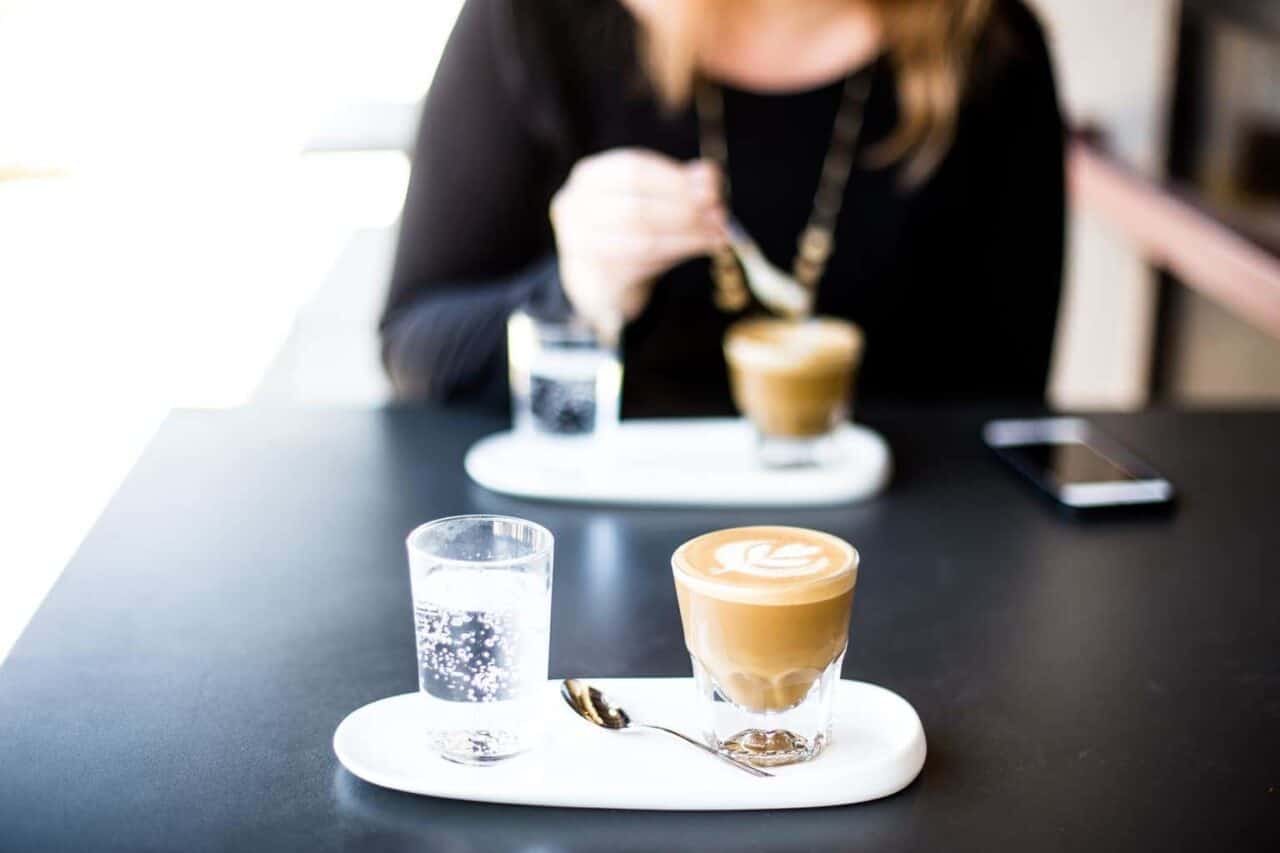 A person sitting at a table with a cup of coffee