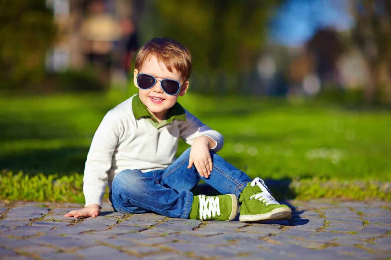 A little boy that is sitting in the grass