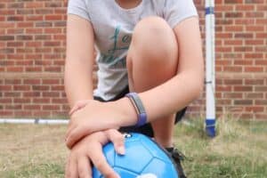 A little girl holding a football ball