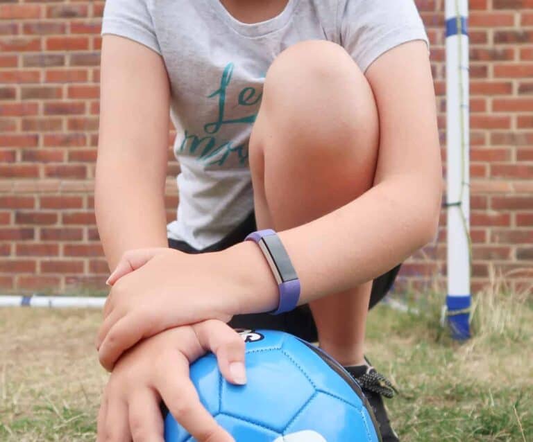 A little girl holding a football ball