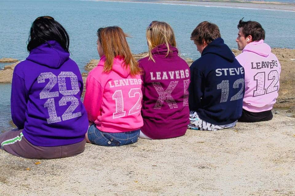 A group of people standing next to a body of water