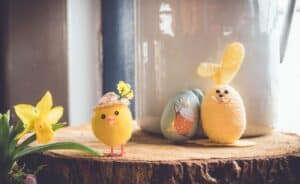 A group of stuffed animals sitting next to a vase