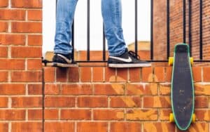 A man standing next to a brick wall