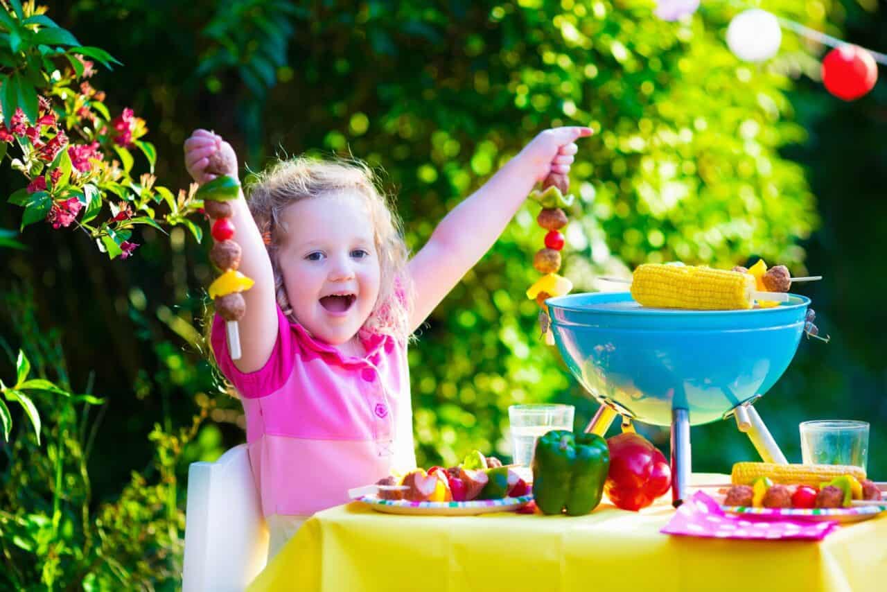 A little girl standing in front of a cake