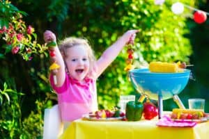 A little girl standing in front of a cake