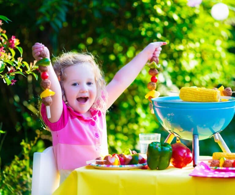 A little girl standing in front of a cake