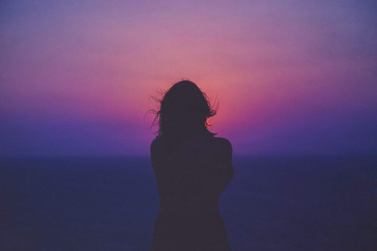 A person standing in front of a sunset