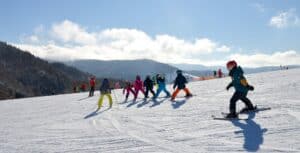 A group of people riding skis down a snow covered slope