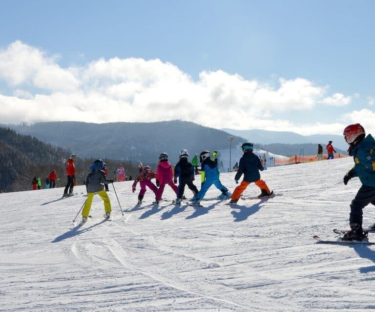 A group of people riding skis down a snow covered slope